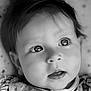baby, close_up, black_and_white, portrait, infant, face, eyes, mouth, hair, clothing, soft_light, curious, cute, young_child, skin, expression, baby_garment, reflection, indoors, adorable