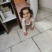 Elena a rejoint le concours — aidez-le/la à gagner de superbes lots ! baby, cabinet, child, clothing, crawling, curious, curly_hair, door, floor, furniture, home, indoor, pacifier, person, playful, room, smile, tile_floor, toddler, young_child