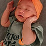 Grace is registered to the contest to win money with this photo: baby, sleeping, headband, orange, bow, green_shirt, text, peach, patterned_pants, blanket, infant, cute, child, resting, soft_texture, closed_eyes, peaceful, lying_down, hand_near_face, portrait