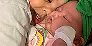 Joseph is registered to the contest to win money with this photo: affection, baby, child, closeup, cuddling, cute, family, green_headband, hugging, indoor, infant, love, newborn, person, rainbow_shirt, sleeping_baby, smiling_child, soft_lighting, toddler, white_clothing
