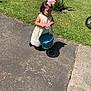 Bailey is registered to the contest to win money with this photo: toddler, child, dress, bow, basket, sidewalk, grass, easter_eggs, outdoor, sunny, shadow, curly_hair, greenery, tree, play, person, walking, holiday, spring, fun