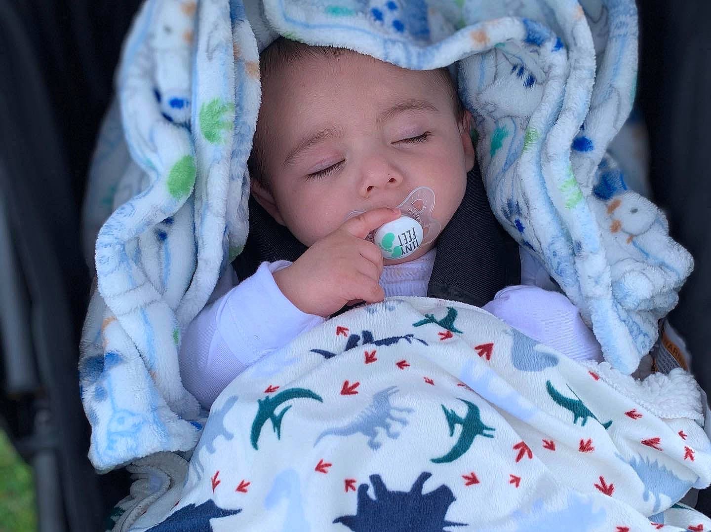 Chico is registered to the contest to win money with this photo: arm, baby, baby_toddler_clothing, cap, cheek, comfort, eye, face, finger, hand, hat, head, lip, mouth, nose, organ, person, product, skin, textile