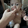 Ronan joined the competition — help win amazing prizes! adult_hand, baby, brick_wall, casual, child, closeup, couch, curious, diaper, expression, finger, hand, holding, indoor, infant, person, portrait, seated, skin, soft_lighting
