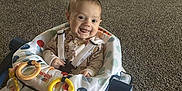 Ronan joined the competition — help win amazing prizes! baby, baby_walker, carpet, child, colorful, comfort, cute, face, furniture, happy, home, indoors, infant, living_room, pajamas, person, play, seat, smiling, toy