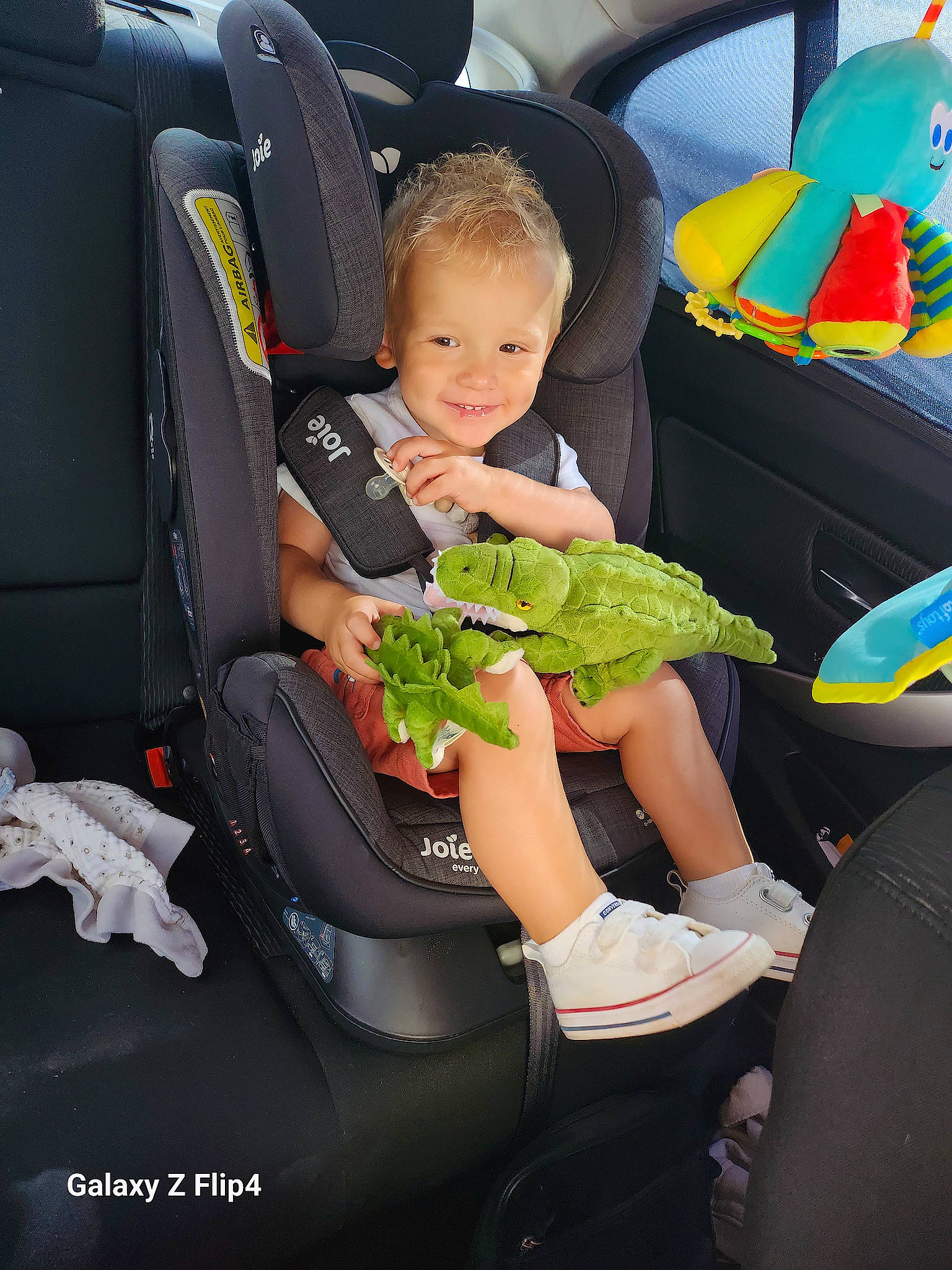 Maé a rejoint le concours — aidez-le/la à gagner de superbes lots ! automotive_design, automotive_exterior, car, car_seat, car_seat_cover, comfort, family_car, fun, grass, green, happy, joy, lap, motor_vehicle, person, plant, shoe, smile, sneakers, toddler