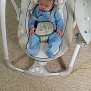 Carmelo is registered to the contest to win money with this photo: baby, sleeping, baby_swing, blue_clothing, carpet, infant, indoor, child, resting, seat, head_support, straps, footwear, furniture, peaceful, toddler, home, soft, comfort, nap