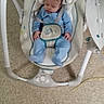 baby, sleeping, baby_swing, blue_clothing, carpet, infant, indoor, child, resting, seat, head_support, straps, footwear, furniture, peaceful, toddler, home, soft, comfort, nap