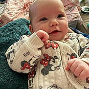 Valerica is registered to the contest to win money with this photo: baby, infant, onesie, mickey_mouse, minnie_mouse, clothing, blanket, face, hand, cute, child, portrait, indoor, cozy, soft, expression, newborn, person, sleepwear, comfort