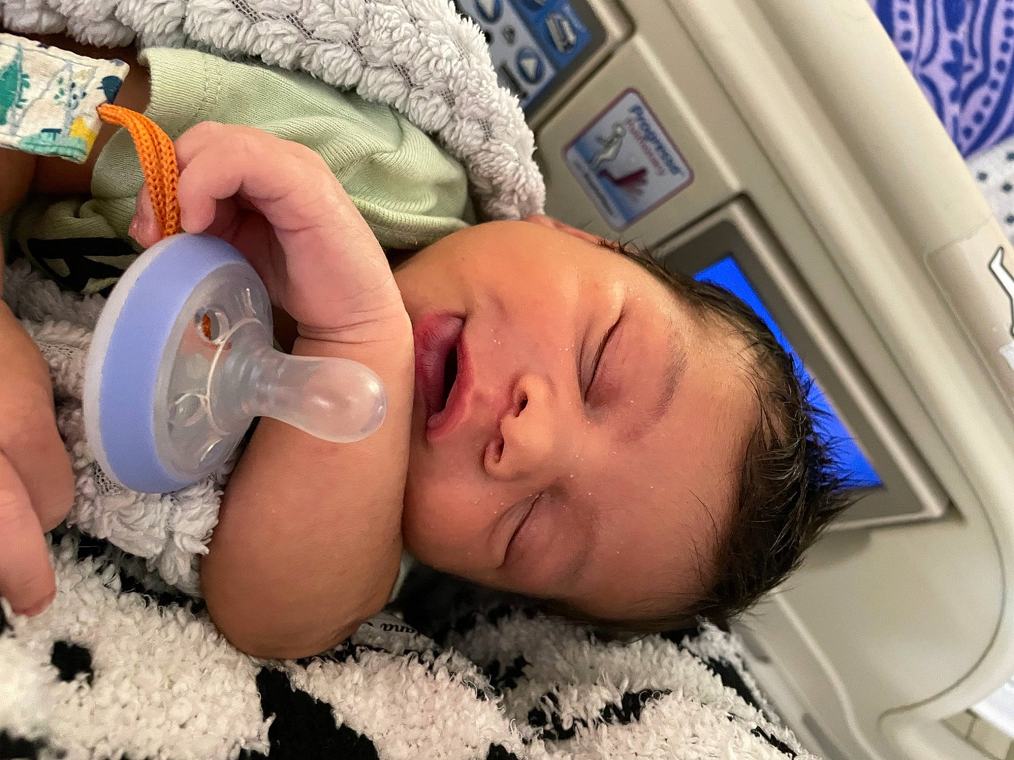 Ethan is registered to the contest to win money with this photo: audio_equipment, baby, cheek, child, comfort, drinkware, ear, eyebrow, eyelash, finger, mouth, nail, nap, nose, person, plastic_bottle, room, service, skin, thumb