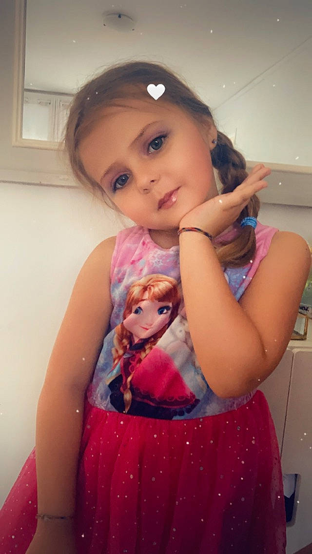 Luna participe au concours pour gagner de l'argent avec cette photo : child, day_dress, doll, eyelash, finger, hair, hairstyle, happy, lip, long_hair, neck, one_piece_garment, person, pink, purple, skin, sleeve, standing, toy, trunk