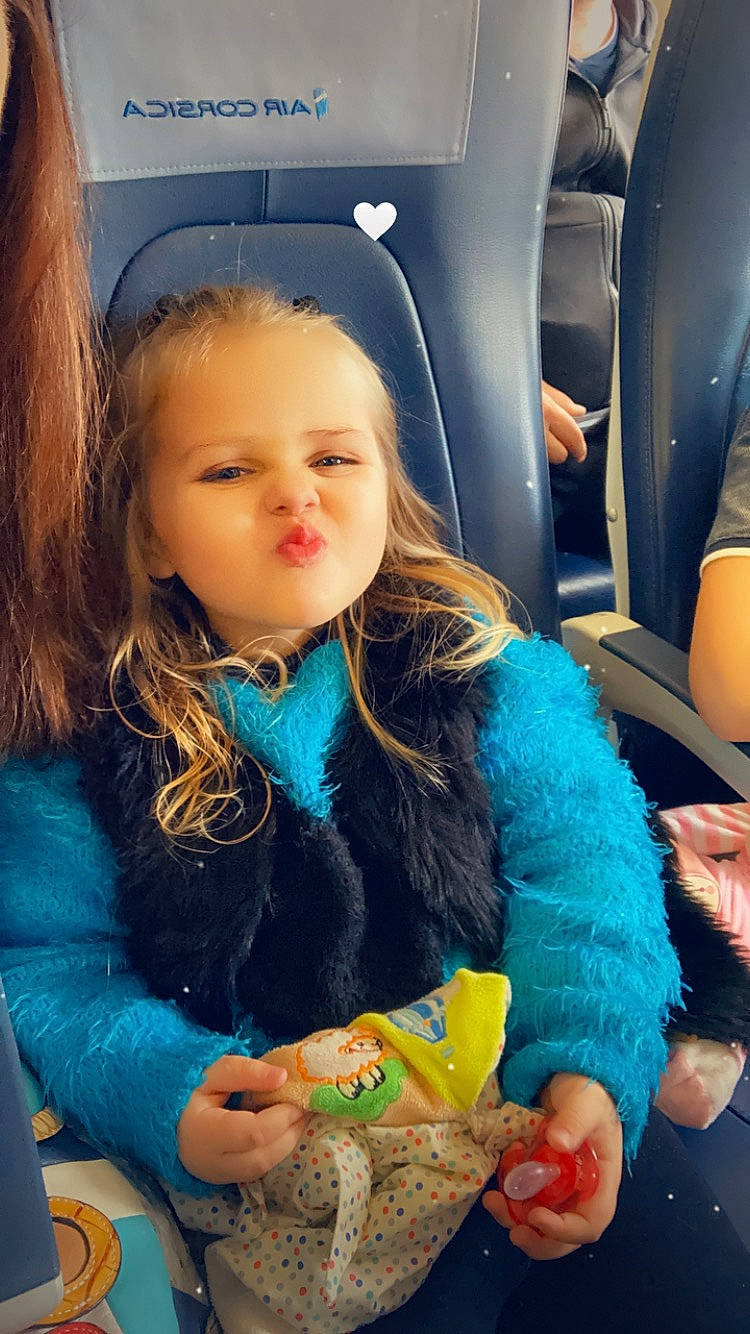 Luna a rejoint le concours — aidez-le/la à gagner de superbes lots ! air_travel, auto_part, car_seat, child, comfort_food, family_car, fun, fur, happy, holiday, iris, jacket, long_hair, motor_vehicle, person, play, recreation, sitting, toddler, vacation