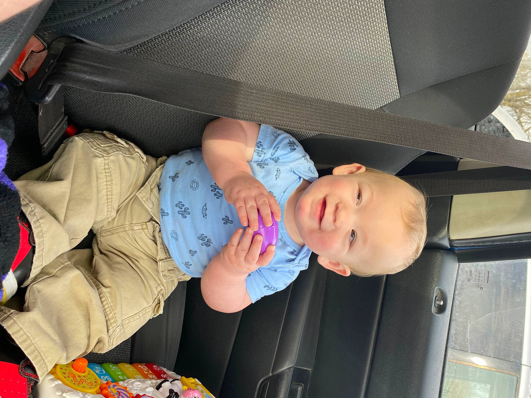 Elliott is registered to the contest to win money with this photo: auto_part, baby, baby_products, baby_toddler_clothing, bag, car_seat, child, comfort, fun, joy, lap, luggage_and_bags, pattern, person, product, sitting, smile, toddler, vacation