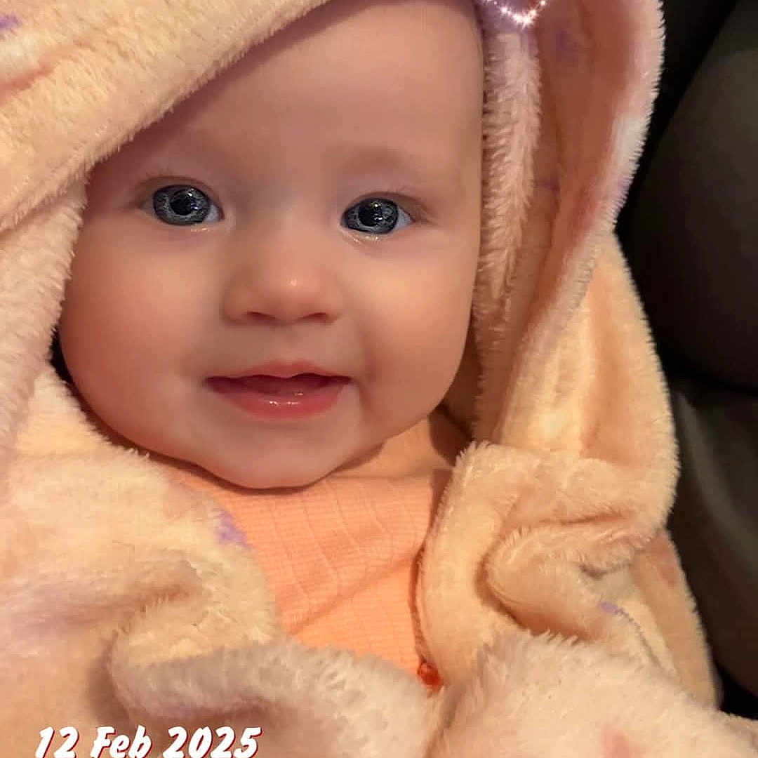 Scarlett-Mae joined the competition — help win amazing prizes! baby, blanket, bonnet, clothing, face, happy, hat, head, hood, hoodie, knitwear, newborn, person, photography, portrait, quilt, smile, sweater, sweatshirt, towel