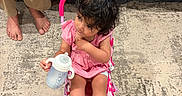Aleezay joined the competition — help win amazing prizes! toddler, child, baby_bottle, pink_stroller, carpet, sofa, bare_feet, indoor, curly_hair, pink_dress, toy, sitting, person, floor, furniture, relaxed, home, young_child, casual, cute