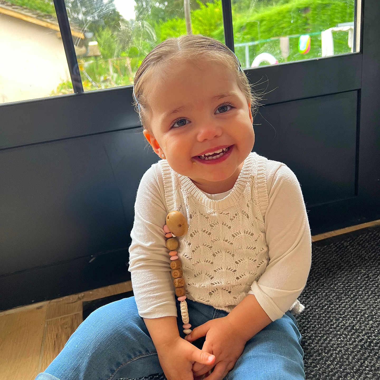 Jade participe au concours pour gagner de l'argent avec cette photo : accessories, baby, bodypart, clothing, face, finger, happy, head, indoors, interiordesign, jeans, jewelry, necklace, pants, person, photography, portrait, sitting, sleeve, smile