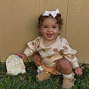 Alayna joined the competition — help win amazing prizes! toddler, child, smiling, grass, outdoor, wooden_fence, bow, fall_clothing, pumpkin_pattern, milestone_sign, happy, cute, baby_shoes, squatting, earrings, nature, portrait, seasonal, playful, young_child