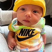 Halo joined the competition — help win amazing prizes! baby, infant, child, nike, hat, yellow, colorful_clothes, pacifier, close_up, portrait, cute, soft_lighting, hand, fabric, apparel, newborn, person, looking, indoors, casual