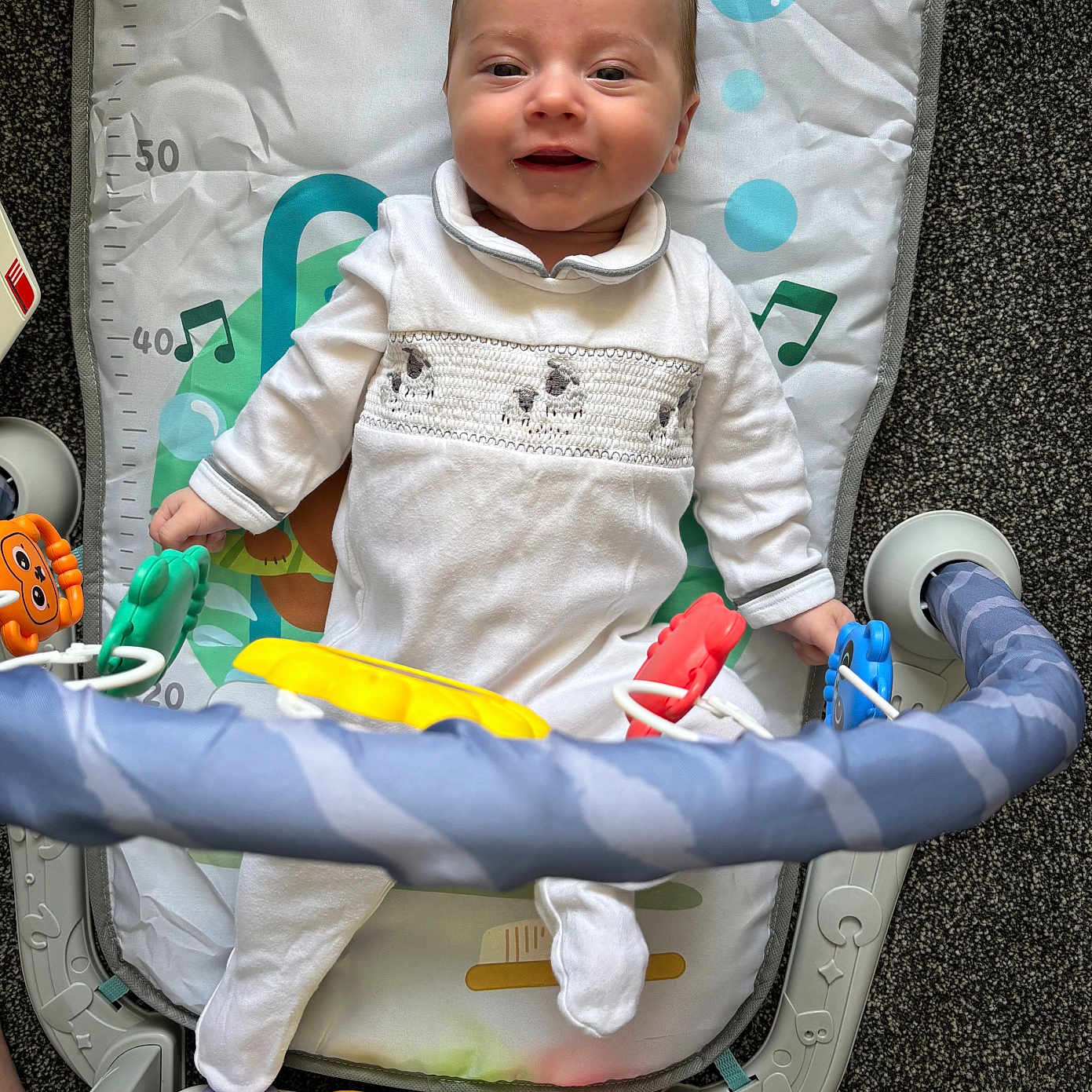 Asher joined the competition — help win amazing prizes! baby, baby_play_gym, carpet, child, childhood, colorful, cute, entertainment, floor, fun, happy, indoor, infant, musical_toys, piano_keyboard, play_mat, smiling, toys, white_onesie, young_child