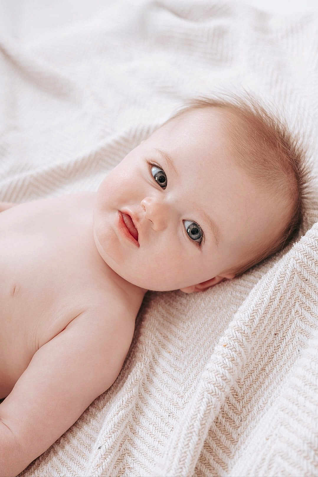 Elenna participe au concours pour gagner de l'argent avec cette photo : baby, infant, portrait, blanket, bedding, blue_eyes, chubby_cheeks, skin, lying_down, head, gaze, newborn, soft_texture, cozy, closeup, adorable, indoor, human, eyelashes, cute
