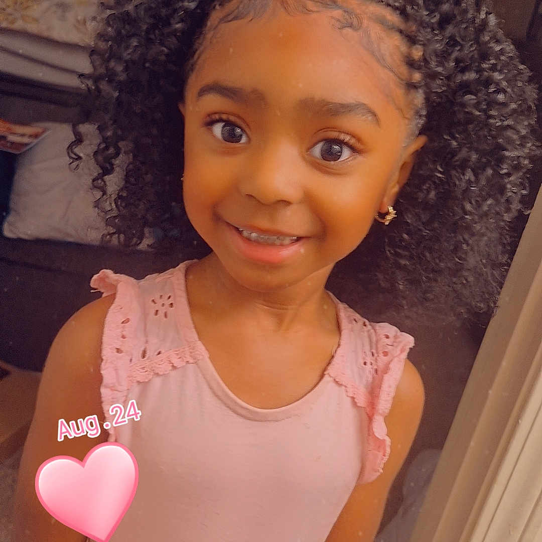 Zereniti is registered to the contest to win money with this photo: brown_skin, casual_clothing, child, childhood, curly_hair, cute, earrings, expression, face, girl, happy, home, indoor, person, pink_top, portrait, pretty, smile, standing, young
