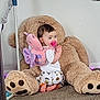 baby, child, toddler, teddy_bear, plush_toy, pacifier, backpack, butterfly, pajamas, floor, carpet, wall, indoor, cute, smile, playful, toy, footwear, person, home