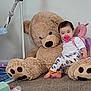 baby, pacifier, teddy_bear, toy, carpet, child, indoor, plush, cute, smiling, pajamas, floor, stuffed_animal, comfort, playtime, childhood, happy, person, young_child, relaxing