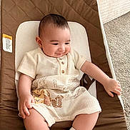Ali is registered to the contest to win money with this photo: baby, infant, child, smiling, baby_seat, clothing, socks, carpet, bed, indoor, cute, relaxed, person, portrait, young_child, comfortable, soft_light, home, seat, resting
