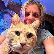 Tuggerpussy is registered to the contest to win money with this photo: animal, blue_light, cat, close_up, earrings, ears, frame, furniture, happy, home_interior, indoor, painting, person, pet, portrait, selfie, smile, t_shirt, whiskers, woman
