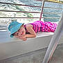 bench, blue_hat, boat, casual, child, concrete_floor, hand, happy, ocean, outdoor, palm_trees, pink_dress, portrait, rail, relaxing, smiling, summer, sunny, vacation, water