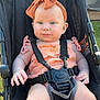 baby, child, stroller, outdoor, sunlight, headband, blue_eyes, peach_clothing, sitting, safety_harness, infant, cute, summer, portrait, young_child, legs, hands, face, expression, relaxation