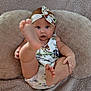 baby, infant, child, headband, foot, barefoot, cute, playful, blanket, pillow, fabric, pattern, animal_print, skin, person, young, indoors, comfort, relax, portrait