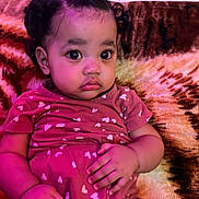 Inaya is registered to the contest to win money with this photo: toddler, child, baby, curly_hair, pink_outfit, hearts_pattern, sitting, blanket, indoor, portrait, cute, big_eyes, curious, cozy, soft_lighting, purple_light, young_child, person, clothing, couch