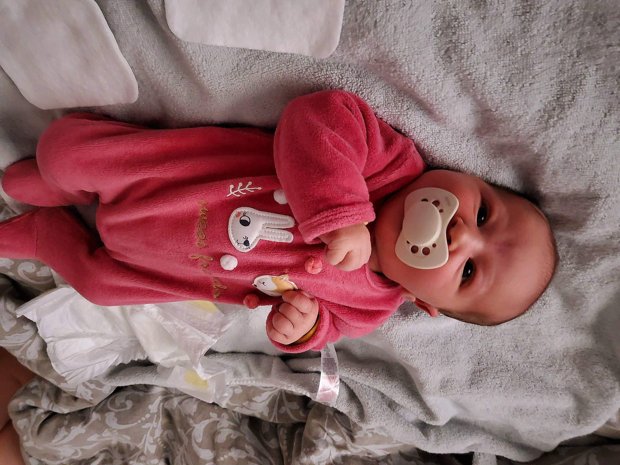 Maddie participe au concours pour gagner de l'argent avec cette photo : arm, baby, baby_toddler_clothing, cheek, comfort, eye, finger, hand, head, headgear, human_body, lip, mouth, nose, person, pink, product, skin, sleeve, smile