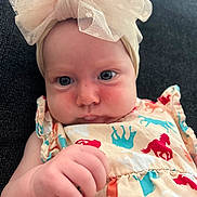 Everley joined the competition — help win amazing prizes! baby, infant, headband, bow, dress, colorful, pattern, horses, hand, face, skin, couch, indoor, portrait, child, curious, closeup, soft_light, clothing, young