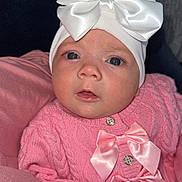 Aurora-Rose is registered to the contest to win money with this photo: adorable, baby, baby_face, blanket, bows, buttoned_sweater, child, closeup, cute, headband, indoors, infant, looking_at_camera, newborn, pink_sweater, portrait, small_hands, soft_texture, warm_clothing, white_bow