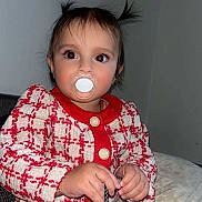 Leyna a rejoint le concours — aidez-le/la à gagner de superbes lots ! baby, child, cute, expression, face, hair, hands, holding, indoor, jewelry, pacifier, patterned_clothing, person, pigtails, portrait, red_jacket, sitting, skin, toddler, young_child