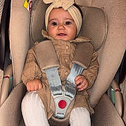 Shëlby participe au concours pour gagner de l'argent avec cette photo : baby, child, car_seat, seat_belt, headband, bow, tights, shoes, beige, clothing, infant, cute, sitting, smile, indoor, safety, portrait, baby_fashion, baby_accessories, car_safety
