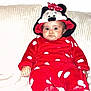 baby, child, infant, red_clothing, polka_dot, minnie_mouse, hood, couch, furniture, indoor, portrait, sitting, cute, drool, wide_eyes, plush, soft_texture, white_background, face, person