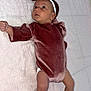 baby, infant, velvet_outfit, headband, bow, blanket, pink, lying_down, curious, skin, feet, hands, indoors, child, newborn, cute, portrait, soft_texture, clothing, expression