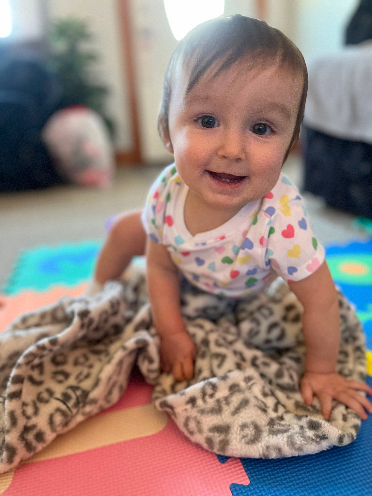 Sophia is registered to the contest to win money with this photo: baby, baby_toddler_clothing, cheek, child, comfort, flooring, fun, hairstyle, happy, joy, leisure, pattern, person, room, sitting, skin, sleeve, smile, t_shirt, textile