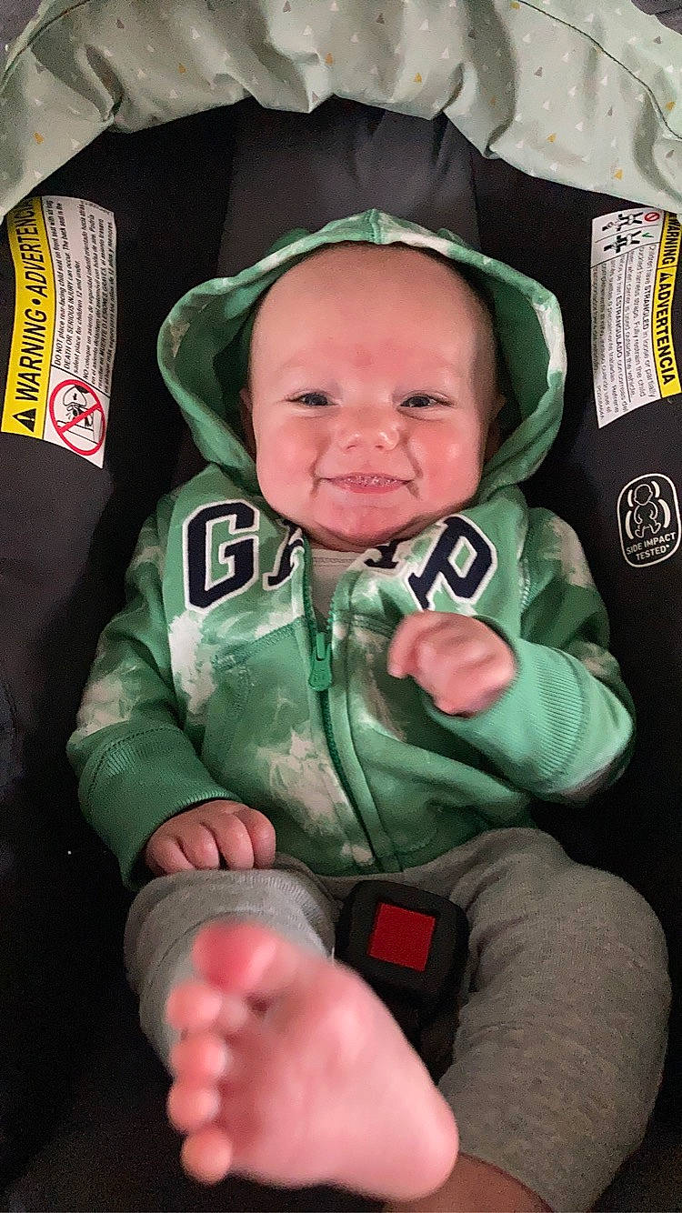 Kylar is registered to the contest to win money with this photo: baby, baby_carriage, baby_products, baby_toddler_clothing, cheek, child, comfort, finger, fun, gesture, grass, happy, jacket, joy, lap, mammal, person, personal_protective_equipment, sleeve, smile