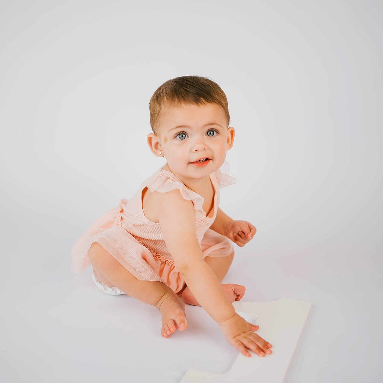 Giada joined the competition — help win amazing prizes! baby, child, toddler, girl, pink_dress, number_one, white_background, sitting, barefoot, portrait, cute, smiling, short_hair, blue_eyes, studio_photo, minimalistic, innocent, playful, hand, floor