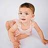 Giada is registered to the contest to win money with this photo: toddler, child, baby, crawling, pink_dress, ruffles, blue_eyes, curly_hair, smiling, cute, portrait, studio, white_background, infant, young_child, happy, person, skin, hands, face