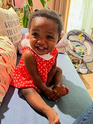 Lillian joined the competition — help win amazing prizes! baby, baby_toddler_clothing, child, dress, event, flooring, foot, fun, happy, head, human_leg, leisure, mouth, pattern, person, plant, sitting, skin, smile, thigh