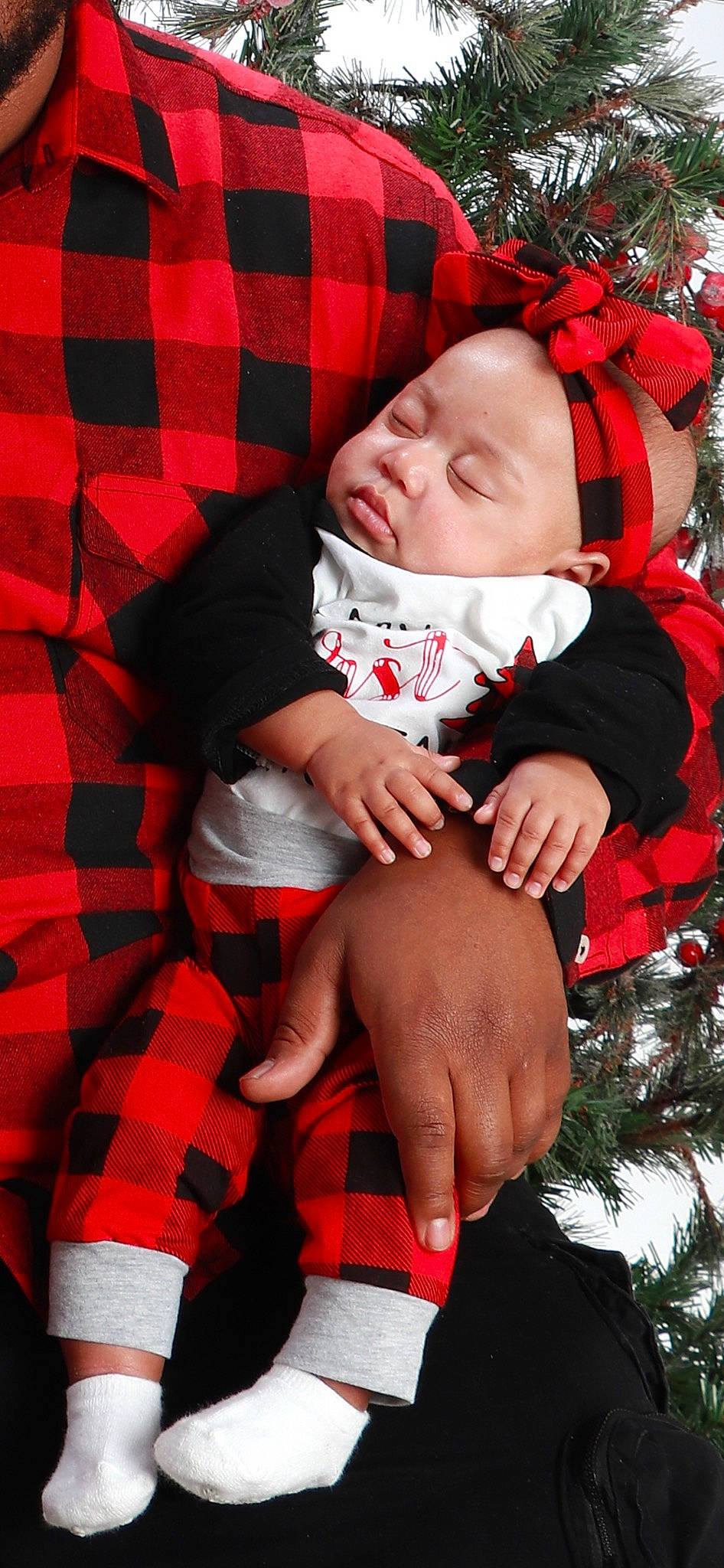 Meilani joined the competition — help win amazing prizes! baby, baby_toddler_clothing, comfort, face, finger, gesture, hand, happy, head, headwear, human_body, organ, outerwear, person, plaid, red, skin, sleeve, tartan, textile