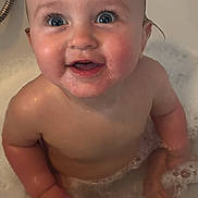 Amelia is registered to the contest to win money with this photo: baby, child, bath, bubbles, water, smile, happy, skin, blue_eyes, wet, foam, cute, infant, indoors, person, head, hand, face, playful, tub