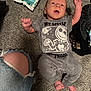 Malakai is registered to the contest to win money with this photo: baby, infant, carpet, clothing, onesie, person, knee, jeans, ripped_jeans, foot, hand, baby_wipes, fabric, floor, cute, expression, lying_down, indoor, casual, child