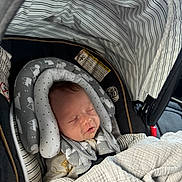 Malakai is registered to the contest to win money with this photo: baby, car_seat, blanket, sleeping, infant, headrest, stripes, cozy, child, safety_harness, interior, cushion, pattern, soft, newborn, seat, nap, comfort, clothing, indoors