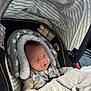 baby, car_seat, blanket, sleeping, infant, headrest, stripes, cozy, child, safety_harness, interior, cushion, pattern, soft, newborn, seat, nap, comfort, clothing, indoors