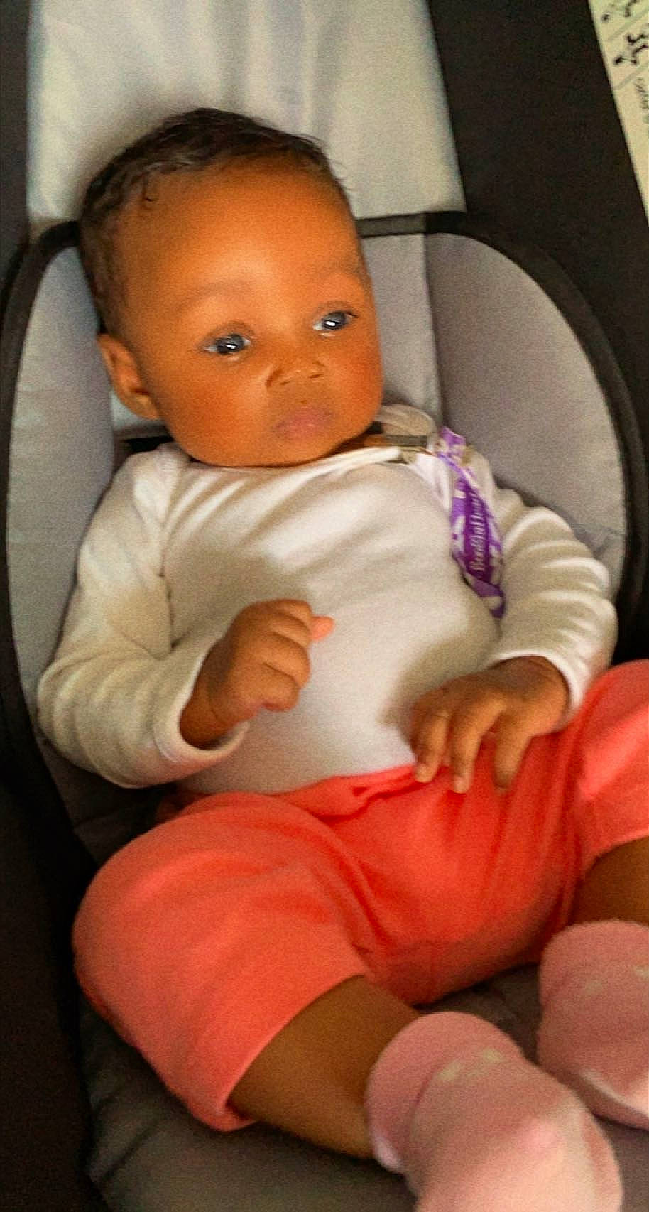 Zariyah is registered to the contest to win money with this photo: arm, baby, baby_toddler_clothing, chair, cheek, comfort, finger, hand, knee, lip, mouth, neck, nose, person, seat_belt, shorts, shoulder, skin, thigh, thumb